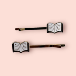 Book lovers enamel hair pin set - A pair of gold-plated hair pins with an open book with white lined pages and a page mark ribbon.